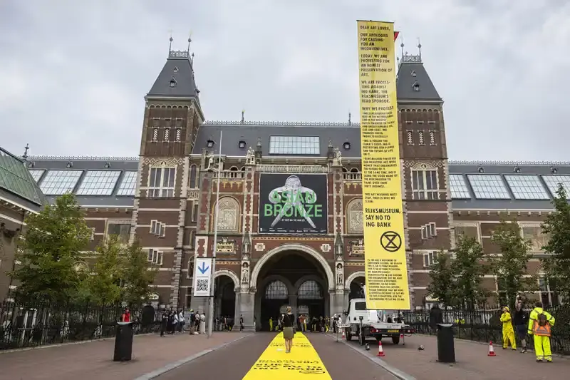 Getty Images Climate activists from Extinction Rebellion protest at Amsterdam's Rijksmuseum, demanding the museum cut ties with ING Bank over climate concerns. Protesters in yellow jumpsuits use smoke bombs and chain themselves to fences, temporarily closing the museum. 33 arrests made as the demonstration highlights the growing trend of targeting cultural institutions for climate activism. (image 2 of 4)