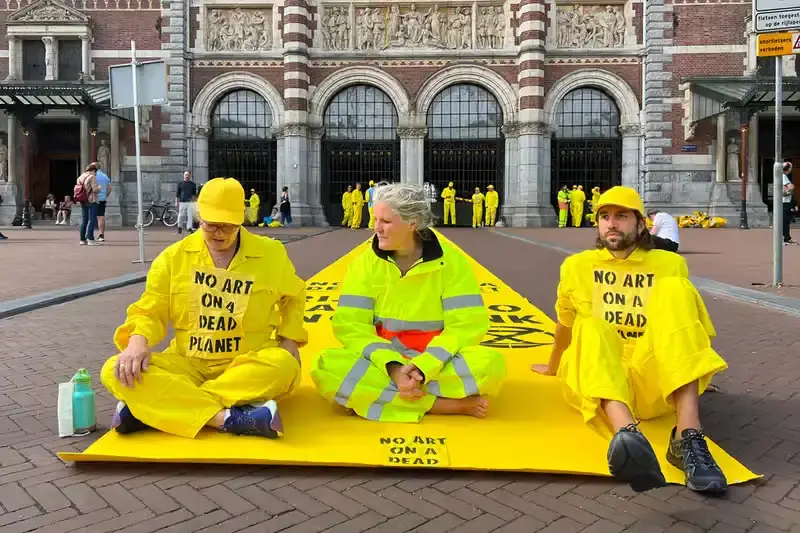 Getty Images Climate activists from Extinction Rebellion protest at Amsterdam's Rijksmuseum, demanding the museum cut ties with ING Bank over climate concerns. Protesters in yellow jumpsuits use smoke bombs and chain themselves to fences, temporarily closing the museum. 33 arrests made as the demonstration highlights the growing trend of targeting cultural institutions for climate activism. (image 3 of 4)