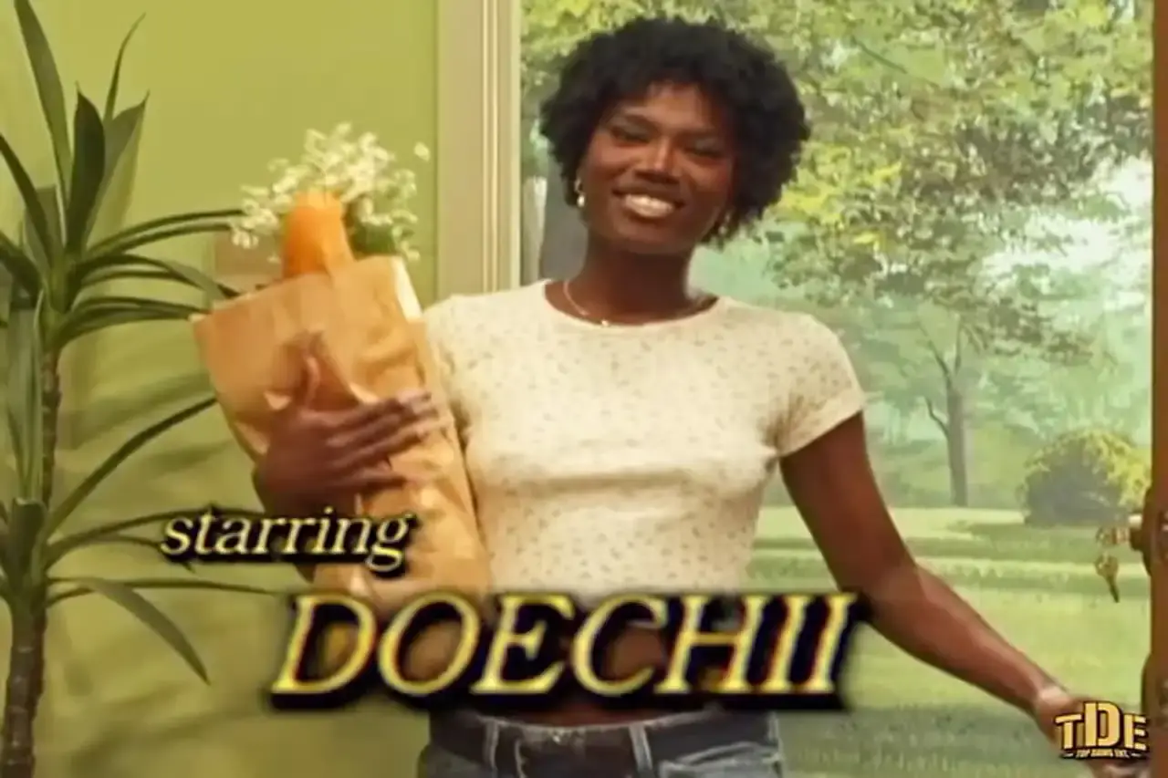 Promotional trailer for 'Denial Is a River' TV series, showcasing Doechii and cast members in a 90s sitcom-style setting against a brightly lit studio background.