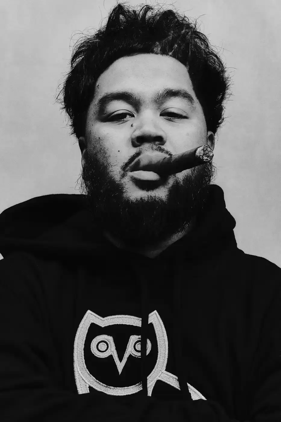 Drake and his OVO team members pose together wearing black hoodies with the OVO owl logo for the new "OG" campaign. The image shows Drake in the center, surrounded by his close associates including Jonny Roxx and Niko Carino. They stand against a plain background, emphasizing the group's unity and the branded clothing. Additional images feature individual shots of each team member modeling various pieces from the new OVO collection, including a letterman jacket and other sweater designs (image 2 of 7)