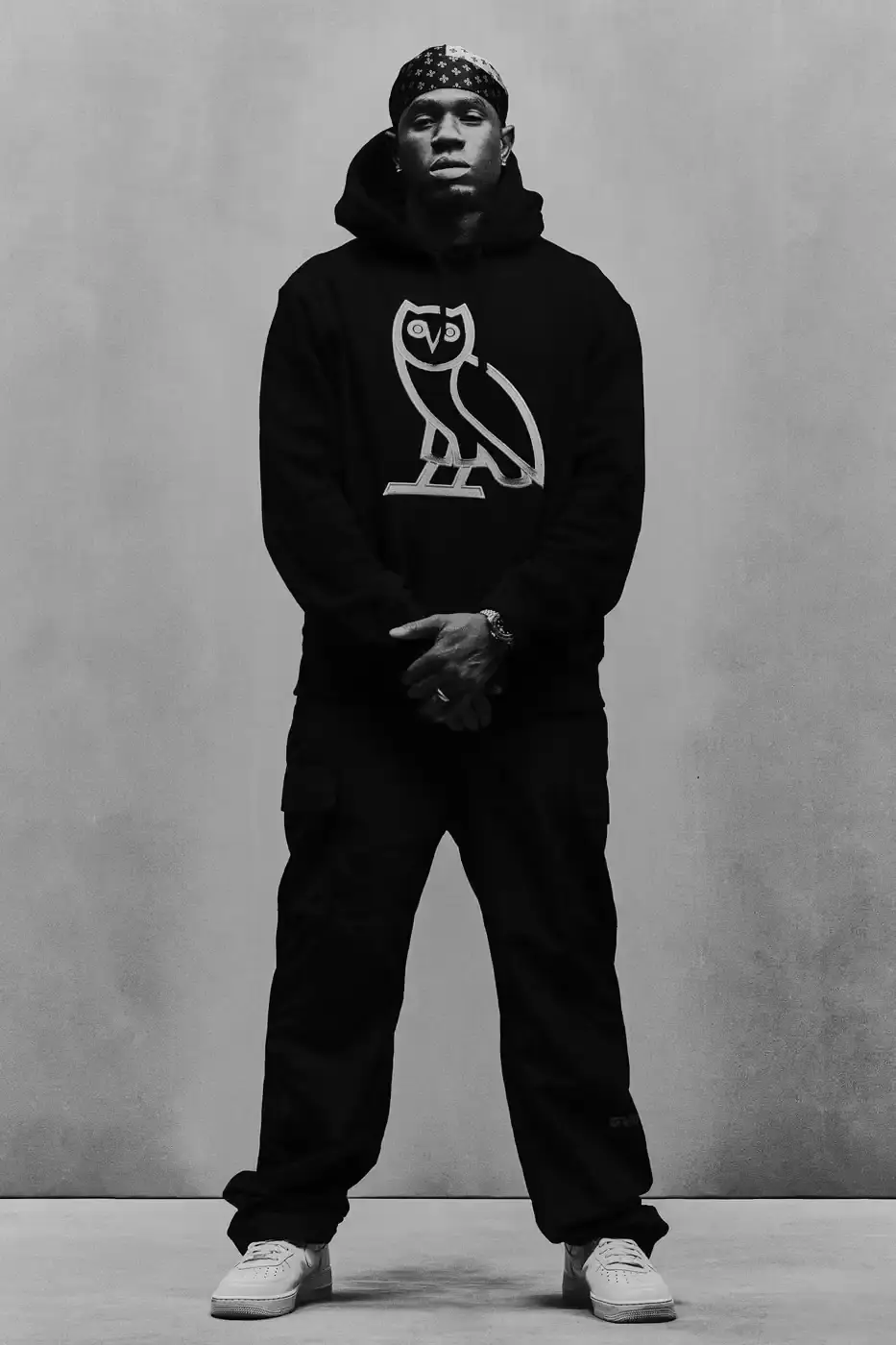 Drake and his OVO team members pose together wearing black hoodies with the OVO owl logo for the new "OG" campaign. The image shows Drake in the center, surrounded by his close associates including Jonny Roxx and Niko Carino. They stand against a plain background, emphasizing the group's unity and the branded clothing. Additional images feature individual shots of each team member modeling various pieces from the new OVO collection, including a letterman jacket and other sweater designs (image 3 of 7)