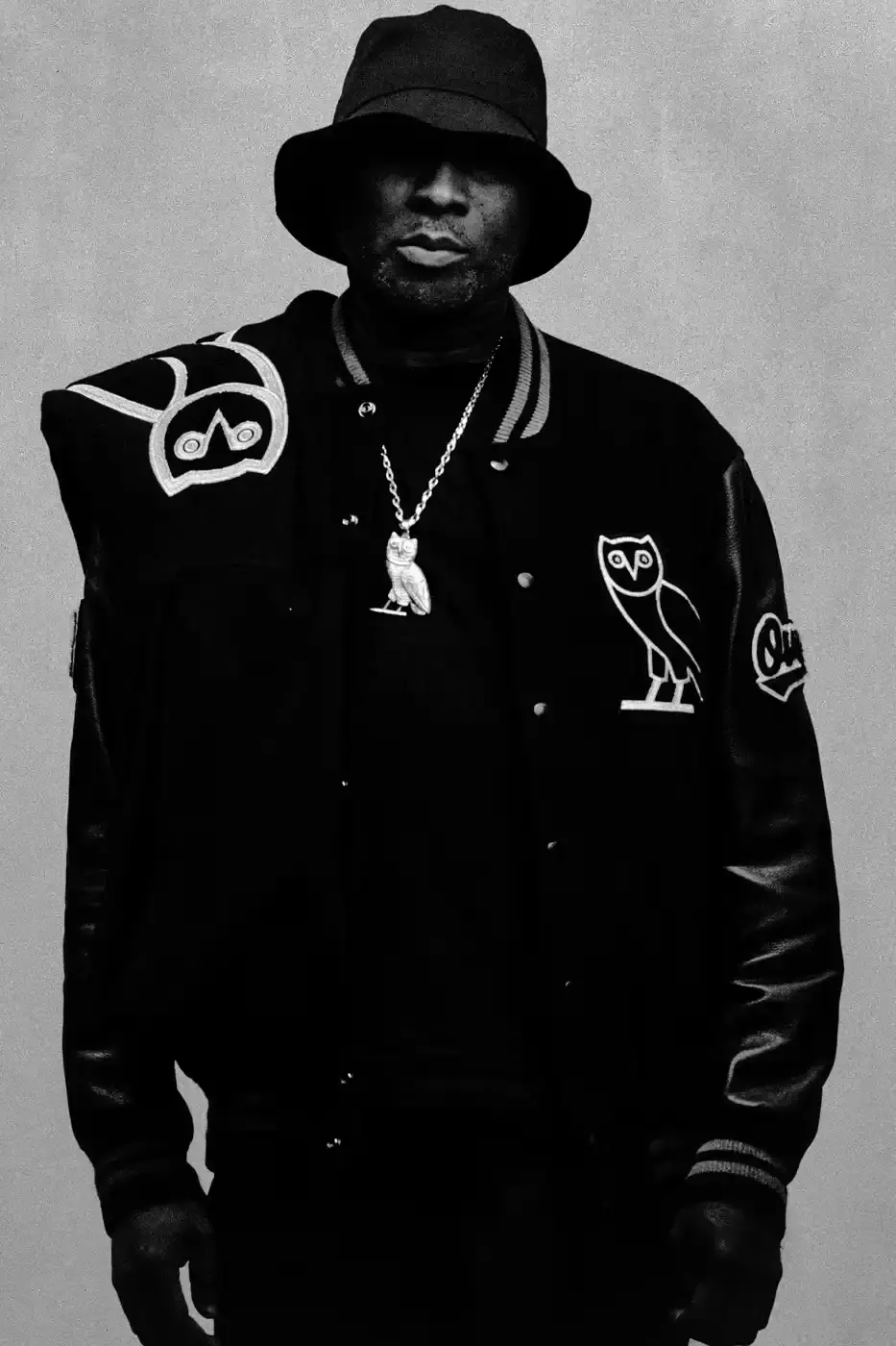 Drake and his OVO team members pose together wearing black hoodies with the OVO owl logo for the new "OG" campaign. The image shows Drake in the center, surrounded by his close associates including Jonny Roxx and Niko Carino. They stand against a plain background, emphasizing the group's unity and the branded clothing. Additional images feature individual shots of each team member modeling various pieces from the new OVO collection, including a letterman jacket and other sweater designs (image 7 of 7)