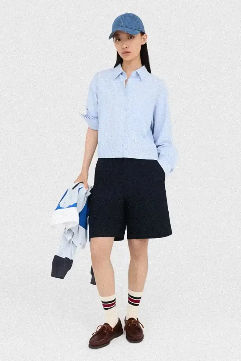 Uniqlo Models wearing Uniqlo x JW Anderson SS25 collection pieces, including blazers, button-ups, and casual wear in neutral tones against a white background (image 8 of 20)
