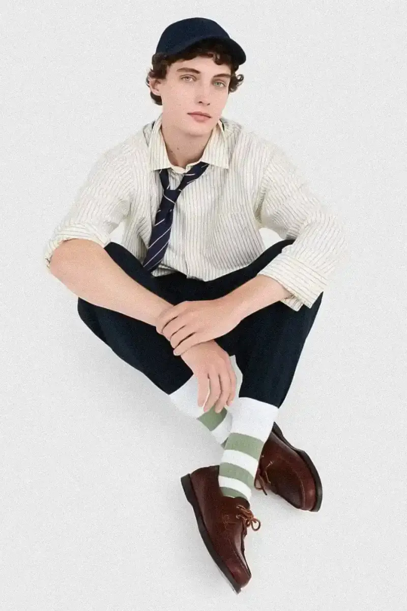 Uniqlo Models wearing Uniqlo x JW Anderson SS25 collection pieces, including blazers, button-ups, and casual wear in neutral tones against a white background (image 6 of 20)