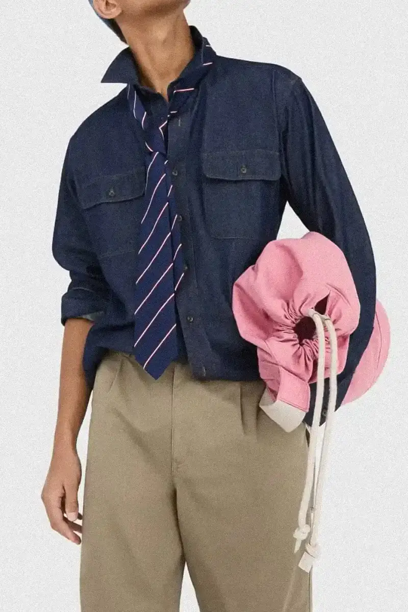 Uniqlo Models wearing Uniqlo x JW Anderson SS25 collection pieces, including blazers, button-ups, and casual wear in neutral tones against a white background (image 3 of 20)