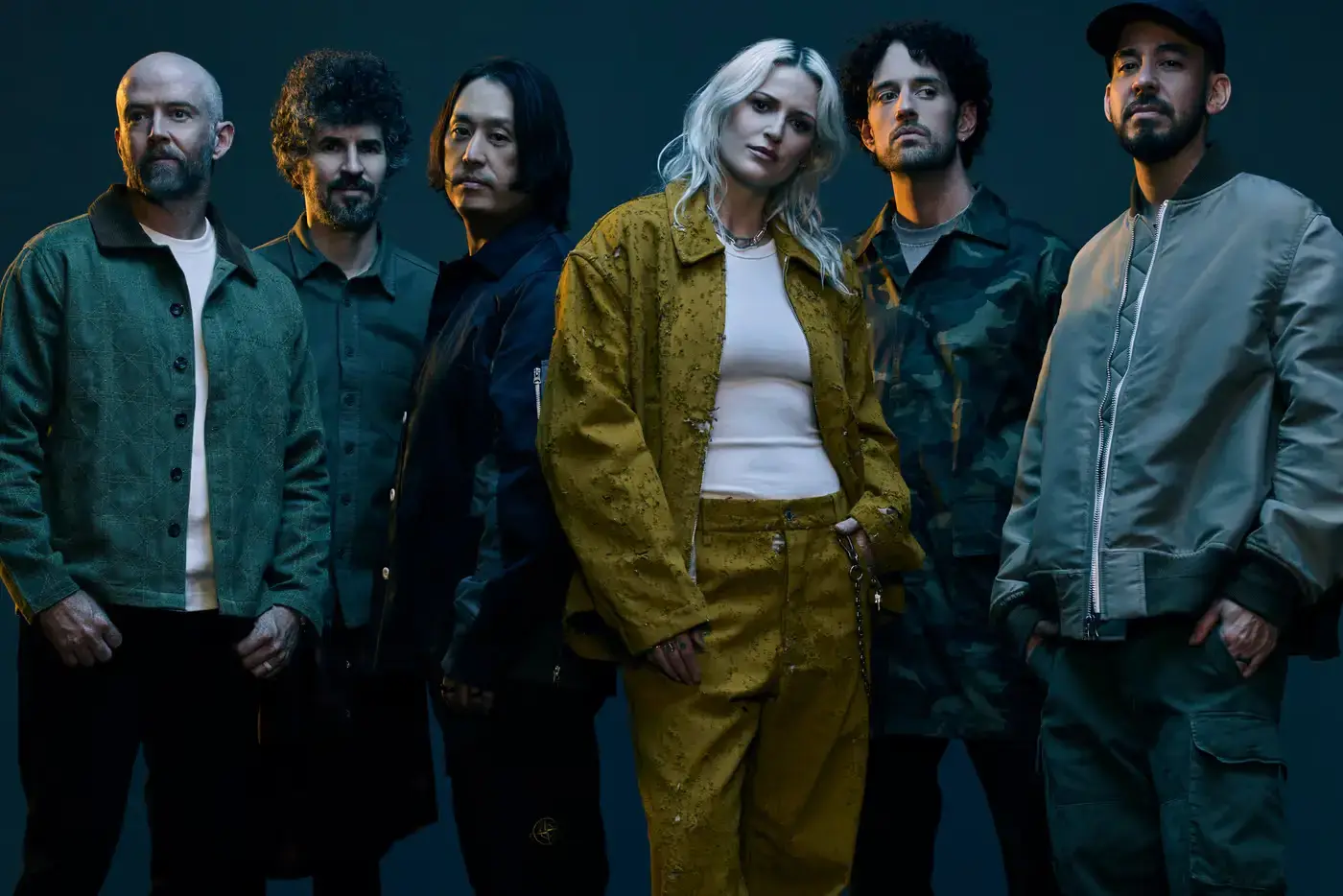 Linkin Park's new lineup featuring Emily Armstrong and Colin Brittain alongside original members, standing together in a recording studio
