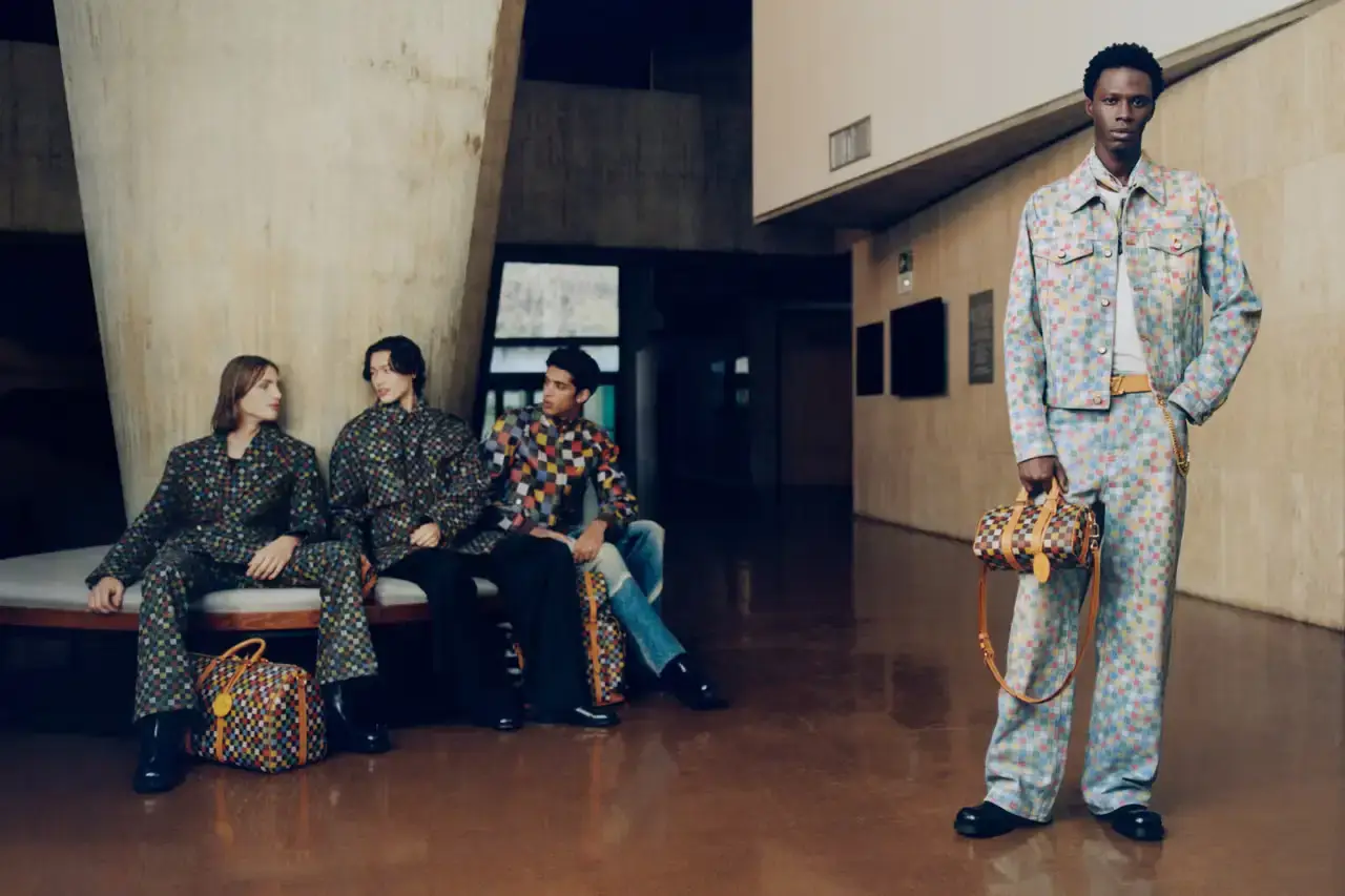 Stef Mitchell Models wearing Louis Vuitton Spring 2025 collection pose in UNESCO's headquarters. They're dressed in earth-toned suits and casual wear, photographed in formal meeting rooms and gardens. The images showcase bags, sunglasses, and diplomatic-inspired fashion against modernist architecture. (image 11 of 15)