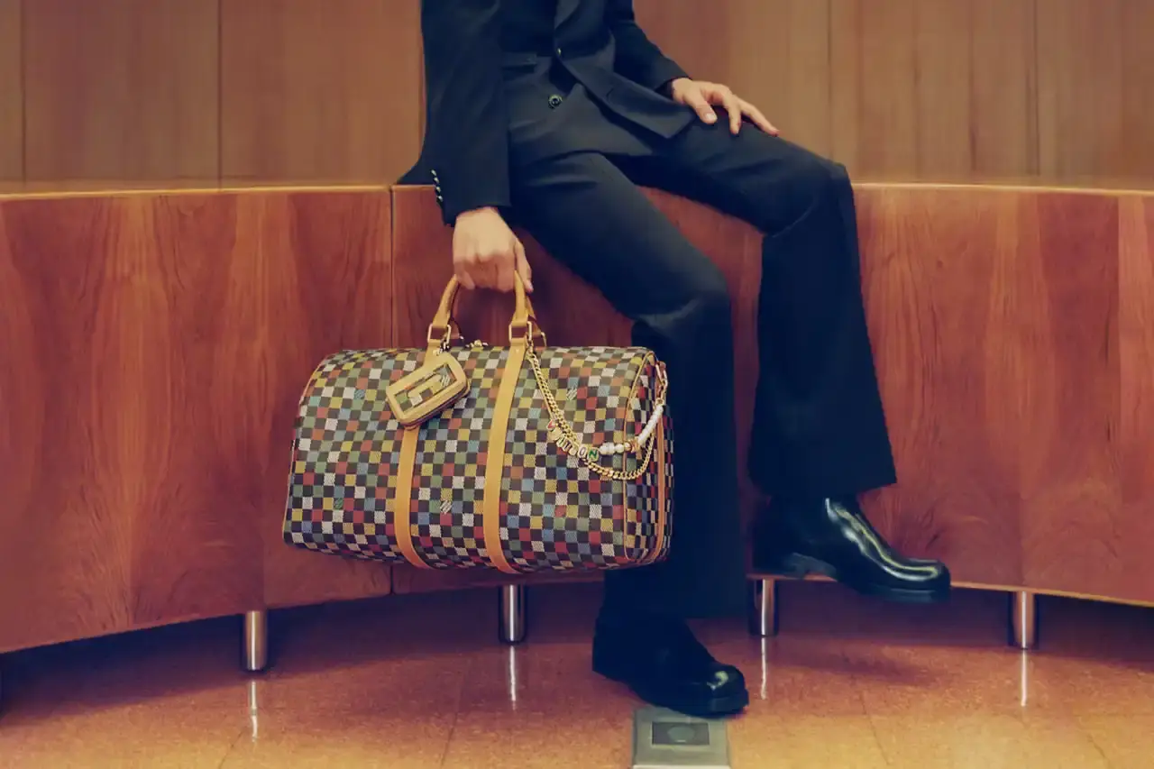 Stef Mitchell Models wearing Louis Vuitton Spring 2025 collection pose in UNESCO's headquarters. They're dressed in earth-toned suits and casual wear, photographed in formal meeting rooms and gardens. The images showcase bags, sunglasses, and diplomatic-inspired fashion against modernist architecture. (image 12 of 15)