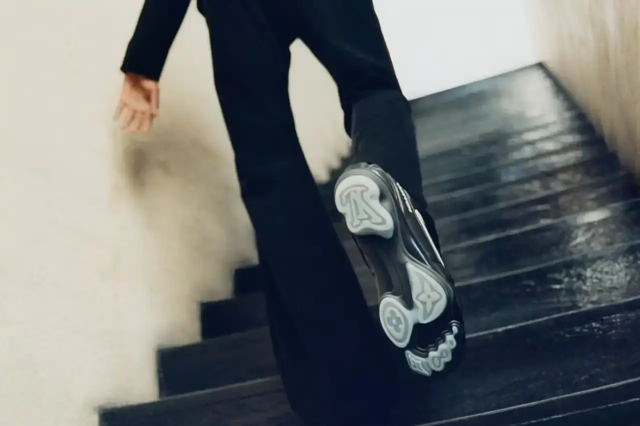 Stef Mitchell Models wearing Louis Vuitton Spring 2025 collection pose in UNESCO's headquarters. They're dressed in earth-toned suits and casual wear, photographed in formal meeting rooms and gardens. The images showcase bags, sunglasses, and diplomatic-inspired fashion against modernist architecture. (image 2 of 15)