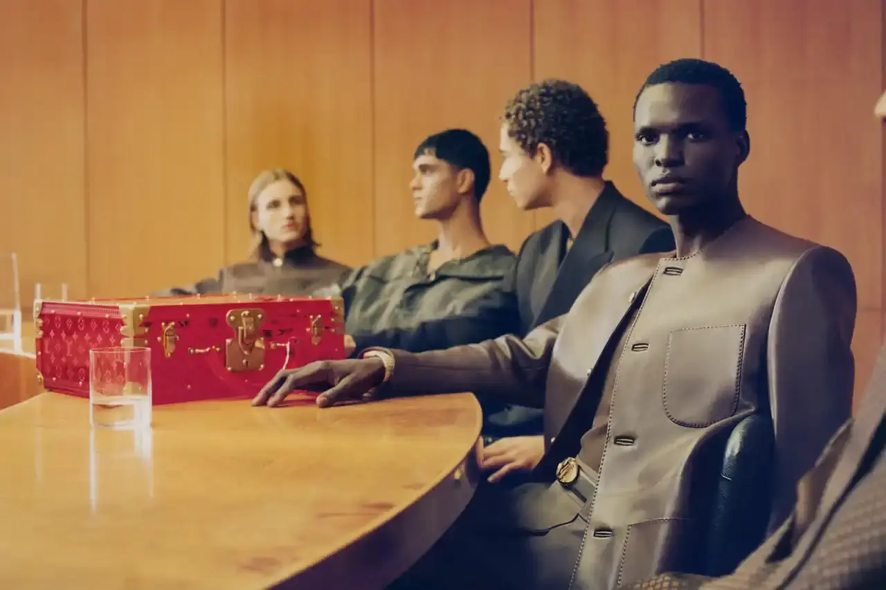 Stef Mitchell Models wearing Louis Vuitton Spring 2025 collection pose in UNESCO's headquarters. They're dressed in earth-toned suits and casual wear, photographed in formal meeting rooms and gardens. The images showcase bags, sunglasses, and diplomatic-inspired fashion against modernist architecture. (image 8 of 15)
