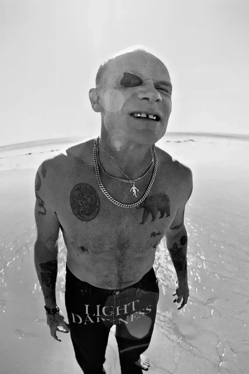 Levi's x UNDERCOVER Flea, bassist of Red Hot Chili Peppers, wearing a dark denim Levi's x UNDERCOVER Pinnacle Type II Trucker Jacket against a neutral background (image 6 of 15)