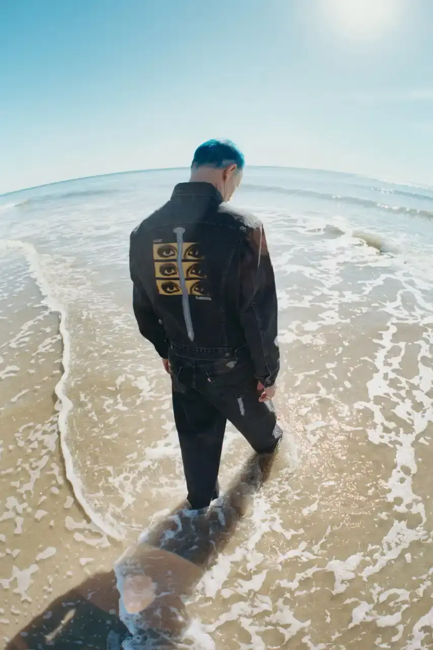 Levi's x UNDERCOVER Flea, bassist of Red Hot Chili Peppers, wearing a dark denim Levi's x UNDERCOVER Pinnacle Type II Trucker Jacket against a neutral background (image 15 of 15)
