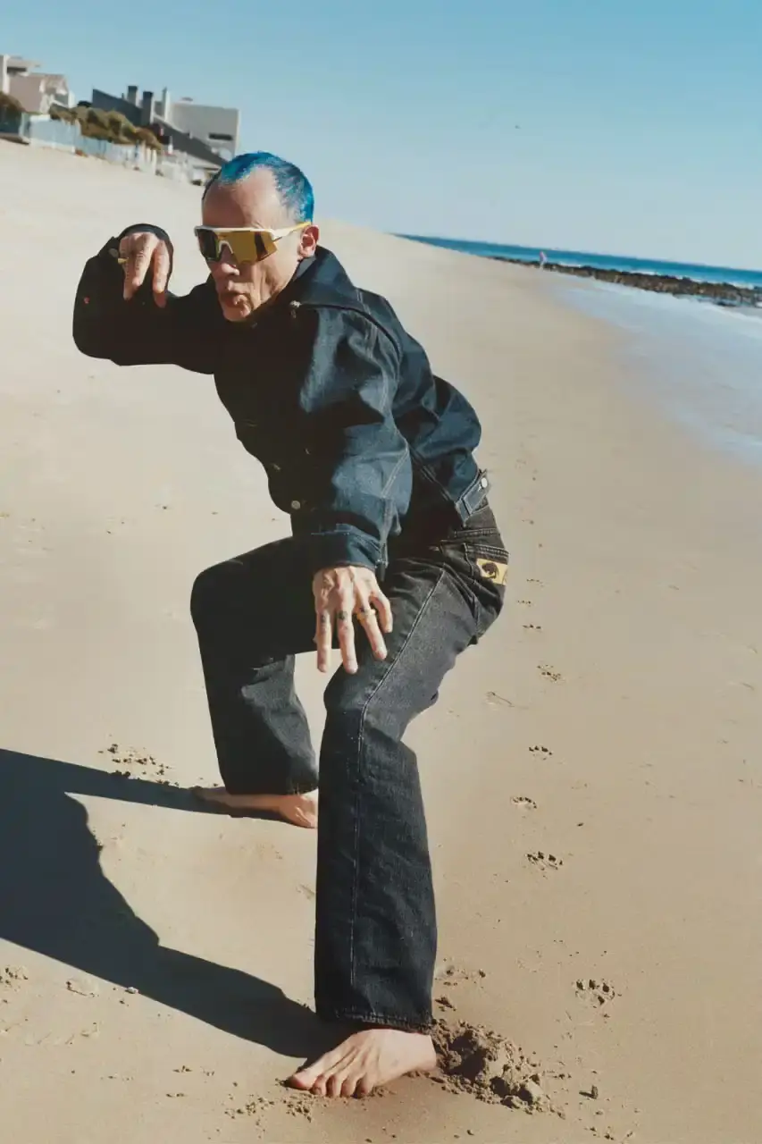 Levi's x UNDERCOVER Flea, bassist of Red Hot Chili Peppers, wearing a dark denim Levi's x UNDERCOVER Pinnacle Type II Trucker Jacket against a neutral background (image 5 of 15)