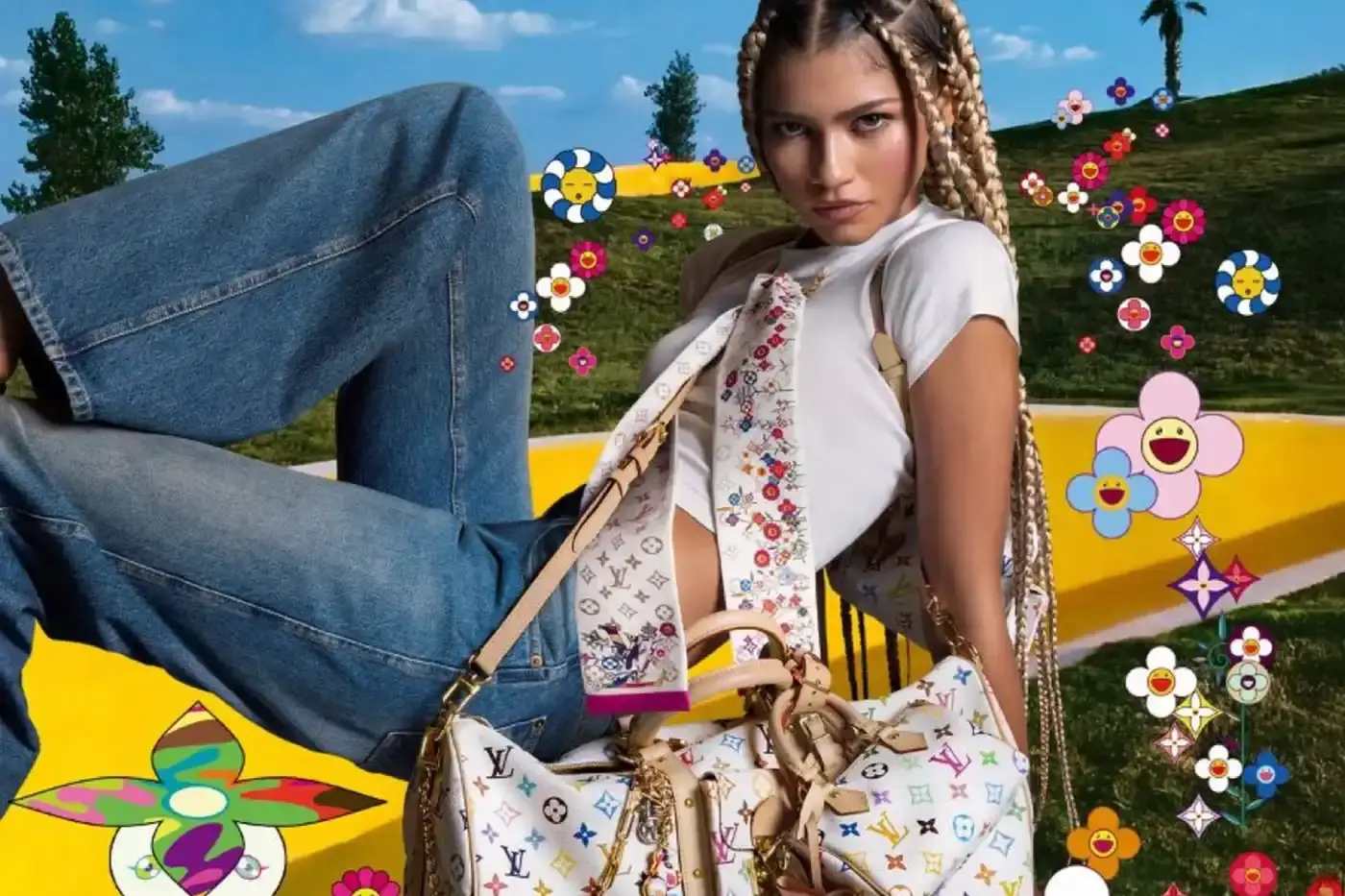 Louis Vuitton Zendaya poses in casual denim and a white crop top against a green screen background with Murakami's floral motifs. She wears a white Louis Vuitton x Murakami bandeau and holds a matching Keepall bag